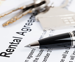 A pen and keys on top of a rental agreement