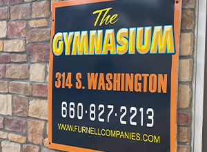 The sign for the Gym on the outside of the building